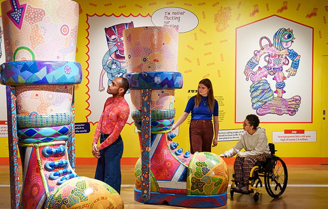 A group of people in an art museum looking at large colourful sculptures