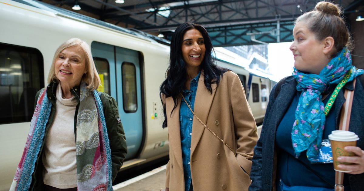 three women smiling getting a thameslink train to bluewater