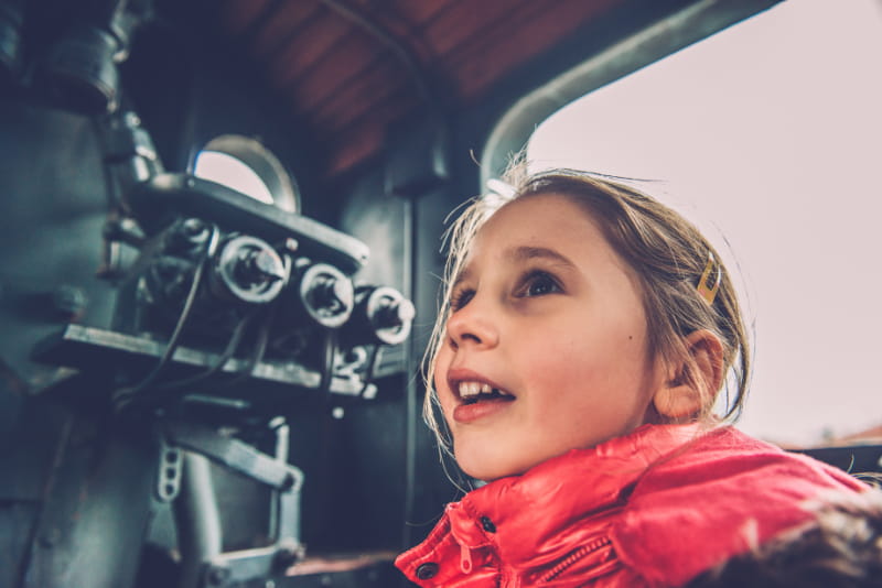 a little girl standing in front of a mirror posing for the camera