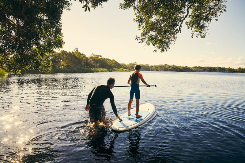 a man standing next to a body of water