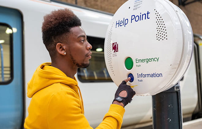 a man standing in front of a help point