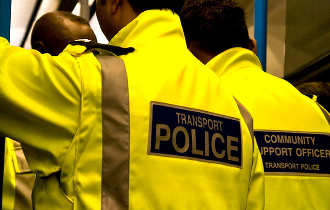 Transport police wearing high visibility jackets while standing on a train