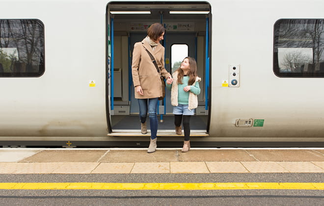 a passenger bus that is stopped at a train station