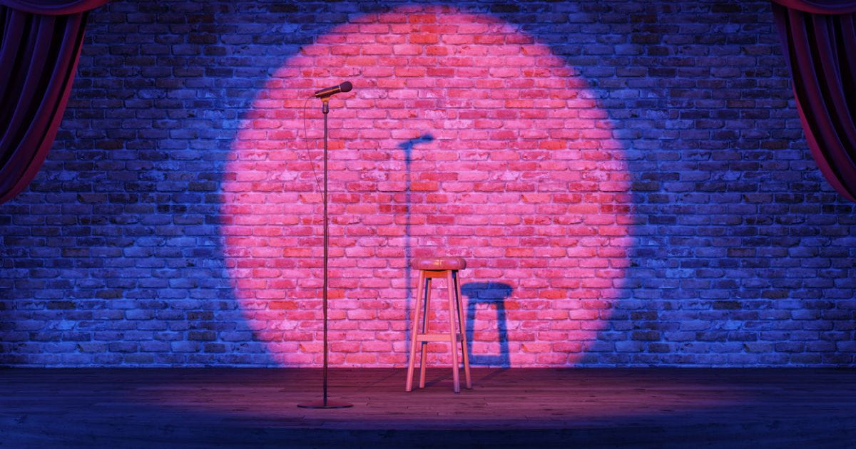 Stock image of a microphone and stool on comedy venue stage