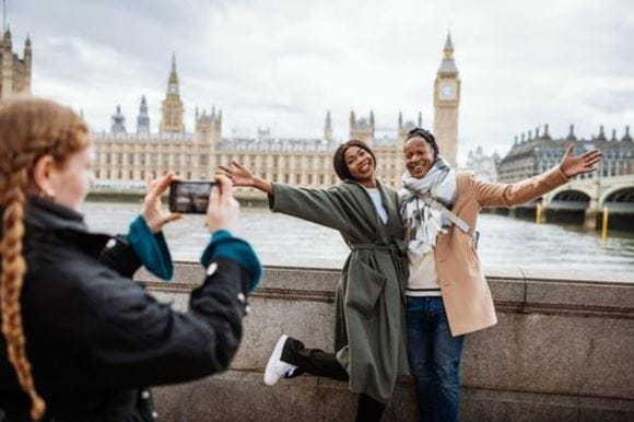 A couple pose in front of Big Ben and have their photo taken
