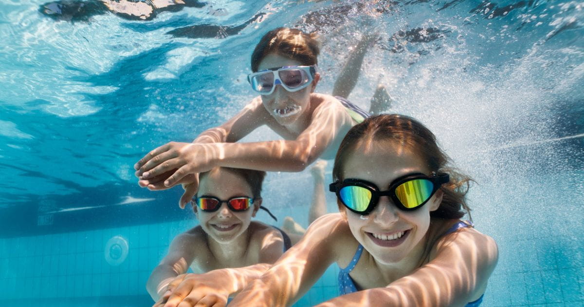 Children swimming under water in a pool